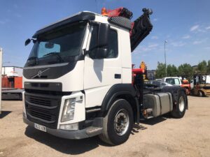 Vista lateral de cabeza tractora Volvo FM con grúa año 2014 en color blanco