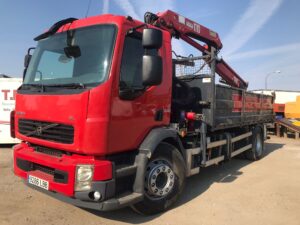 Camión Volvo FL con caja basculante de hierro y grúa HMF con capacidad de 2.400 kg a 4,3 metros